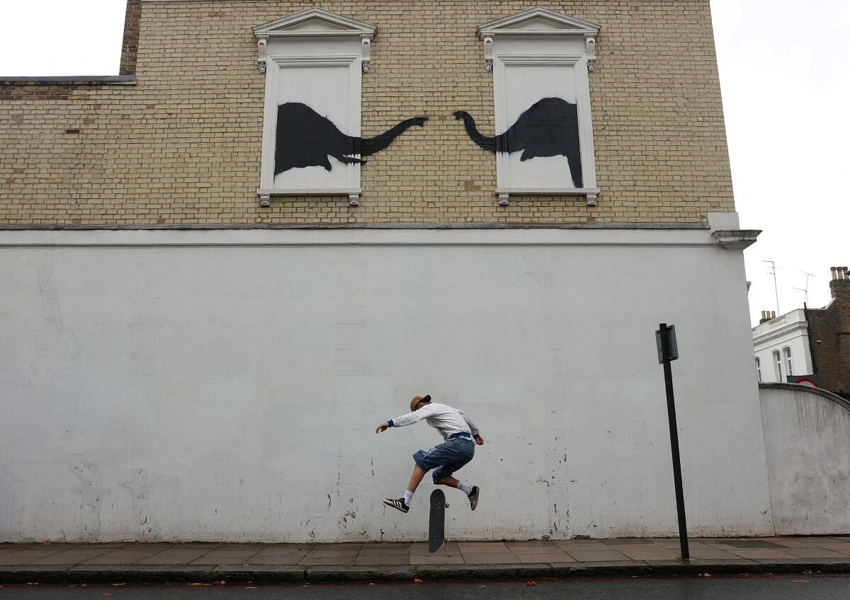 A person skateboards by a new artwork by the British artist Banksy, in Fulham, London, Britain, August 6, 2024.