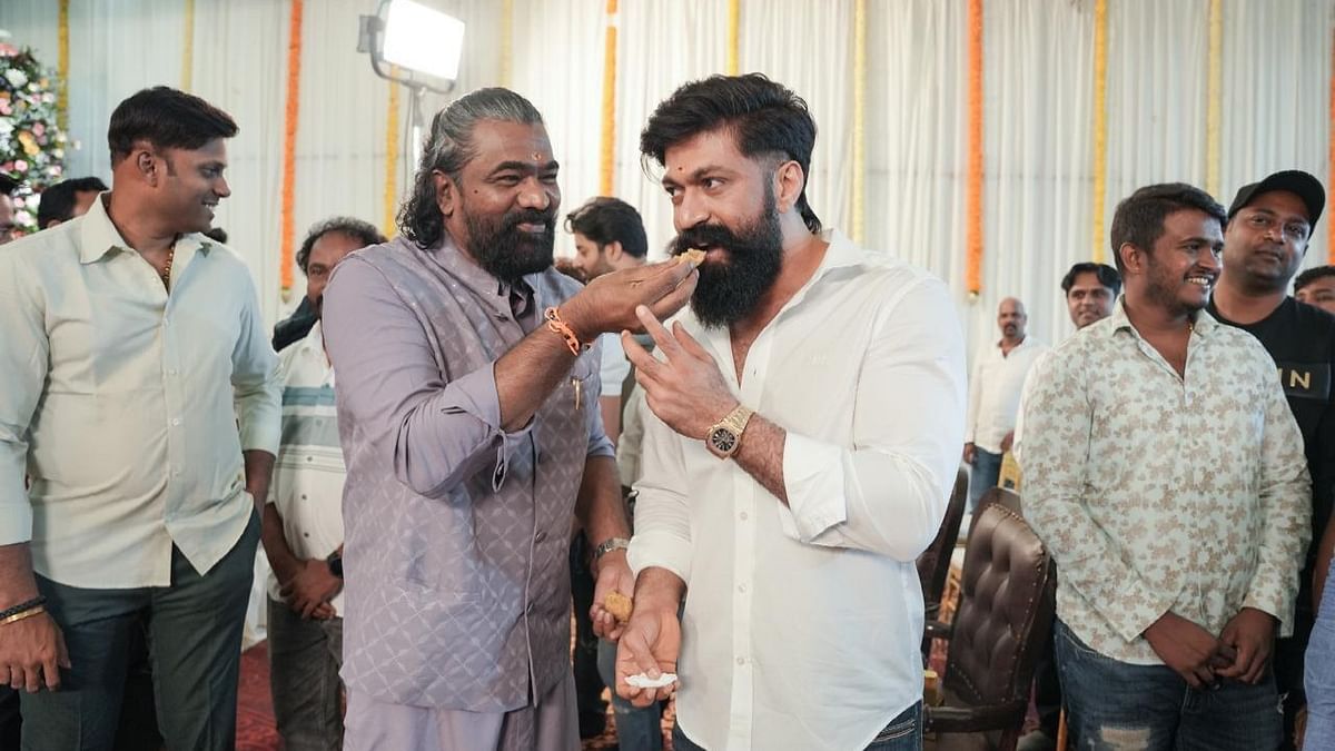 Producer Venkat K Narayana is seen feeding Yash a sweet during the mahurat of Toxic, in Bengaluru.