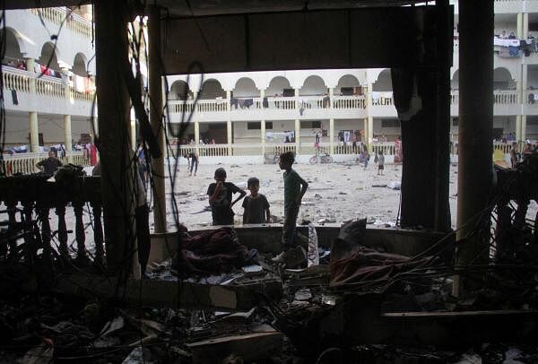 Palestinians look at the damage at the site of an Israeli strike on a school sheltering displaced people, amid the Israel-Hamas conflict, in Gaza City August 10, 2024.