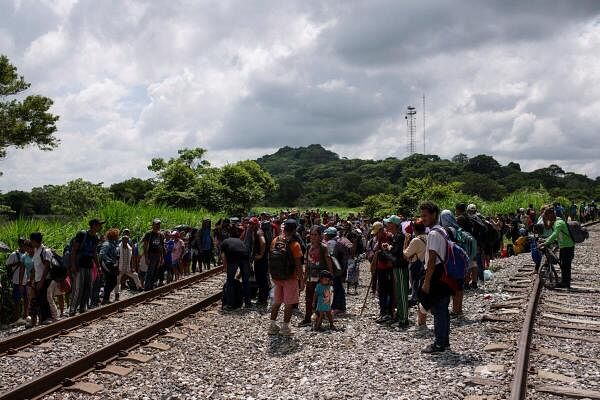 Migrants stand by tracks as they wait for a freight train during their journey toward the US border, in Sayula de Aleman, Veracruz state, Mexico.