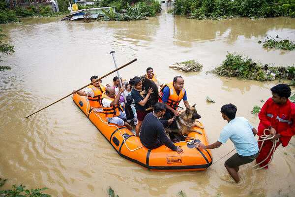 Personnel from Tripura Disaster Management Authority evacuate people from a flood-affected area following heavy rainfall, on the outskirts of Agartala.