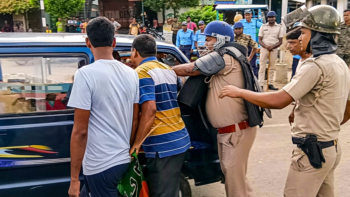 Police personnel try to stop BJP workers from blocking a vehicle during the party's 12-hour general strike in Bengal.