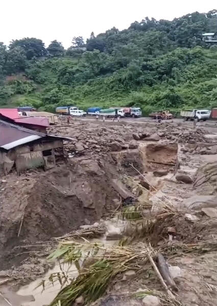 Houses and major portions of National Highway-29, connecting Kohima with commercial hub Dimapur, damaged after heavy rainfall, in Chumoukedima district of Nagaland, Wednesday, Sept. 4, 2024. One person died and several others were reported missing in the tragedy, according to officials.