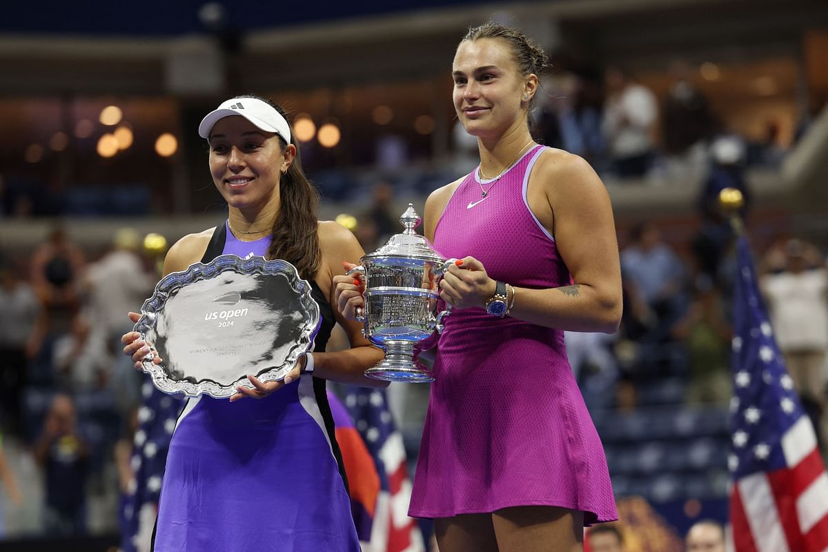 Belarus' Aryna Sabalenka celebrates with her trophy after winning her final match as Jessica Pegula of the US holds her runners up trophy