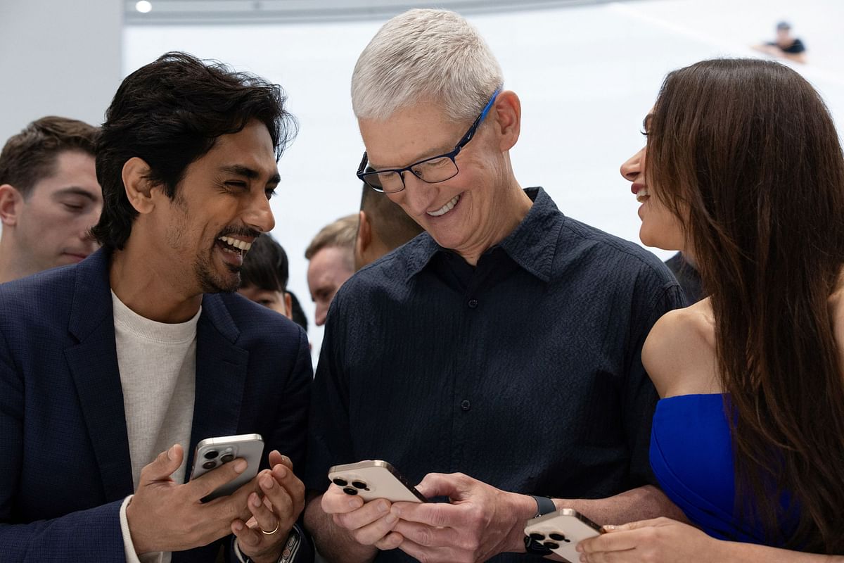 CEO of Apple Tim Cook looks at the new iPhone 16 with Siddharth Suryanarayan and Aditi Rao Hydari as Apple holds an event at the Steve Jobs Theater on its campus in Cupertino, California, US September 9, 2024.