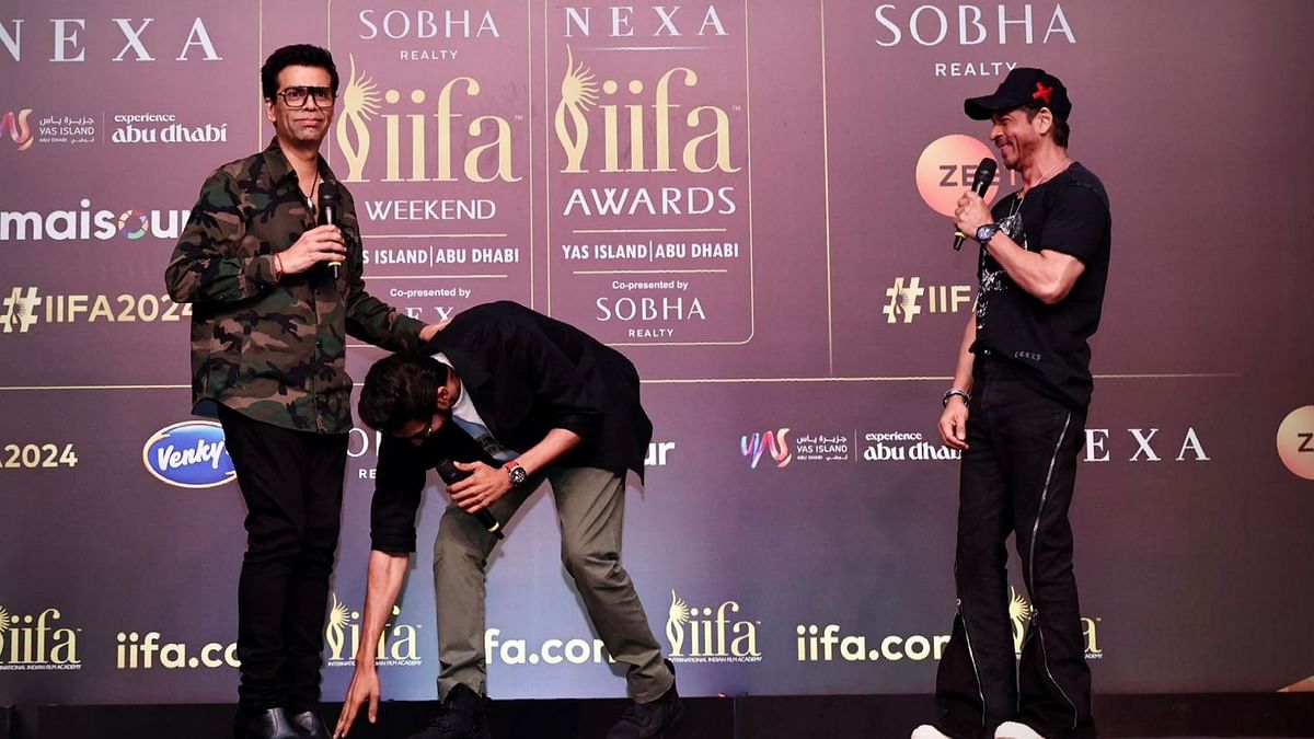 Rana Daggubati touches Karan Johar's feet as Shah Rukh Khan looks on.