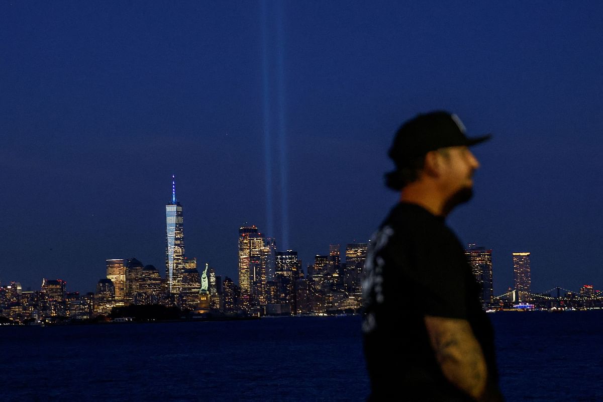 A man arrives to see the Tribute in Light as it is illuminated on the skyline of lower Manhattan on the day of the 23rd anniversary of the September 11, 2001 attacks on the World Trade Center, as viewed from Bayonne, New Jersey, US, September 11, 2024.