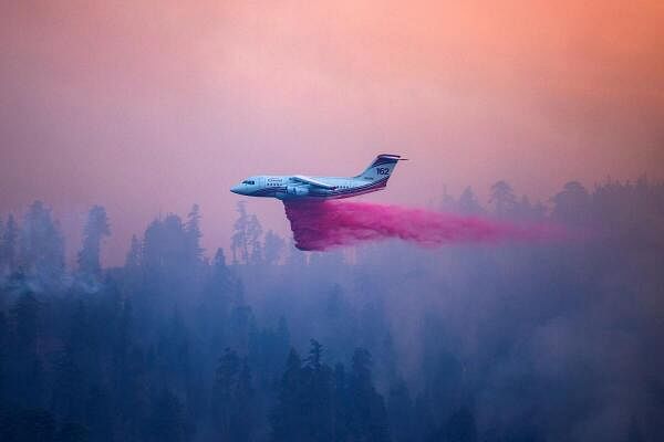 A plane drops retardant on the Bridge Fire threatening mountain communities to the northeast of Los Angeles, in Wrightwood, California