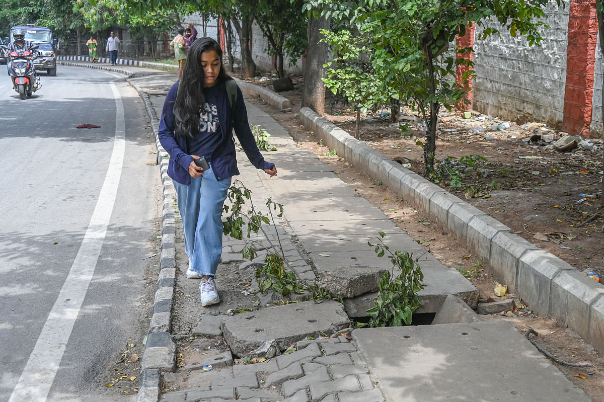 Pedestrians struggle to walk on footpath due to slabs broken sewage is open at Palace road opp Mahendra India Garage Vasantha nagara in Bengaluru on Friday 13th September 2024. 