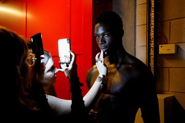 A person applies makeup on a model backstage during rehearsal on the day of the Patrick McDowell catwalk show during London Fashion Week in London, Britain