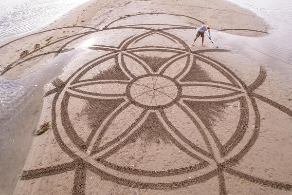 A drone view shows artist Nikola Faler working on sand drawing in the mouth of the river Neretva during the 4th Sand Art Festival near Ploce, Croatia