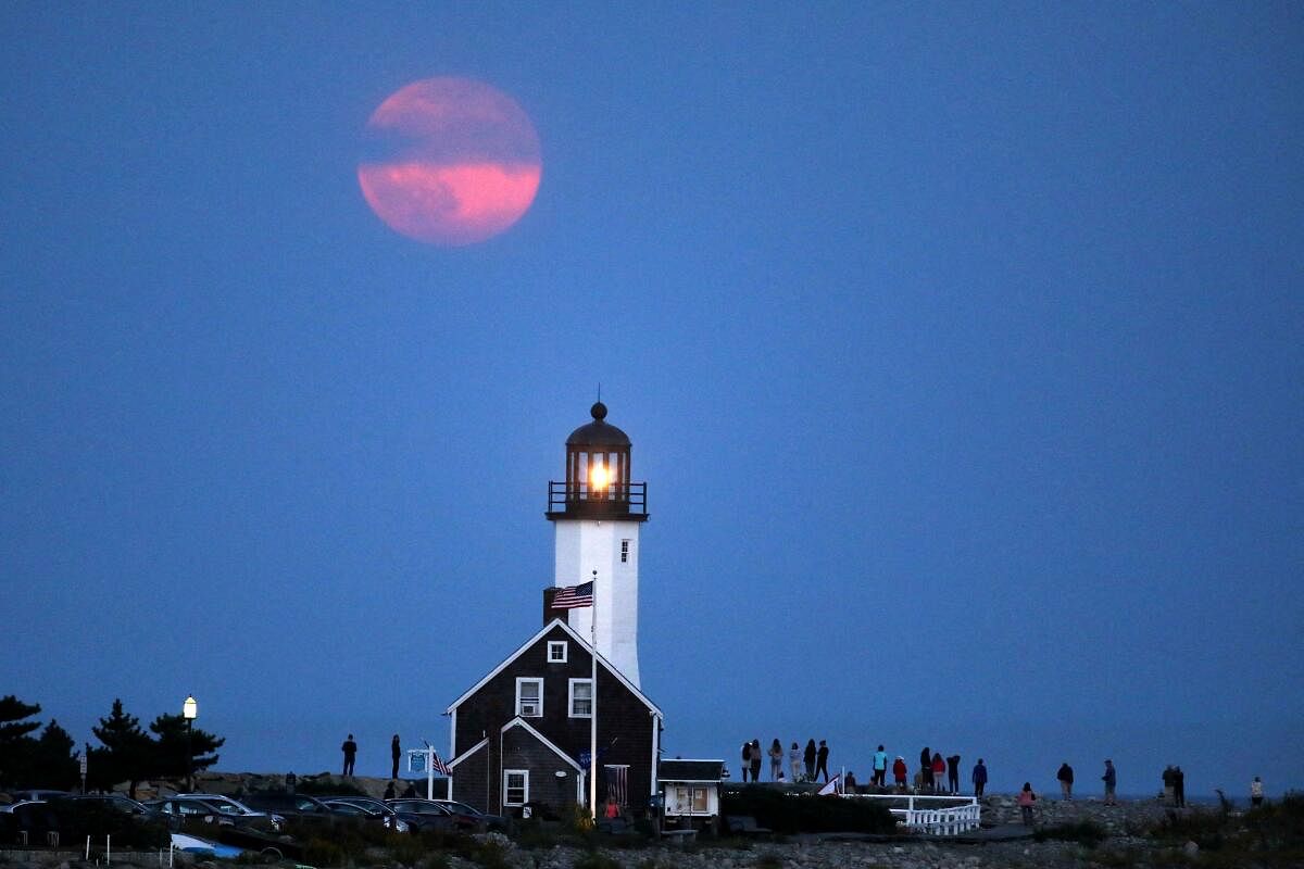 A Harvest Supermoon rises over a lighthouse in Scituate, Massachusetts, U.S., September 17, 2024.