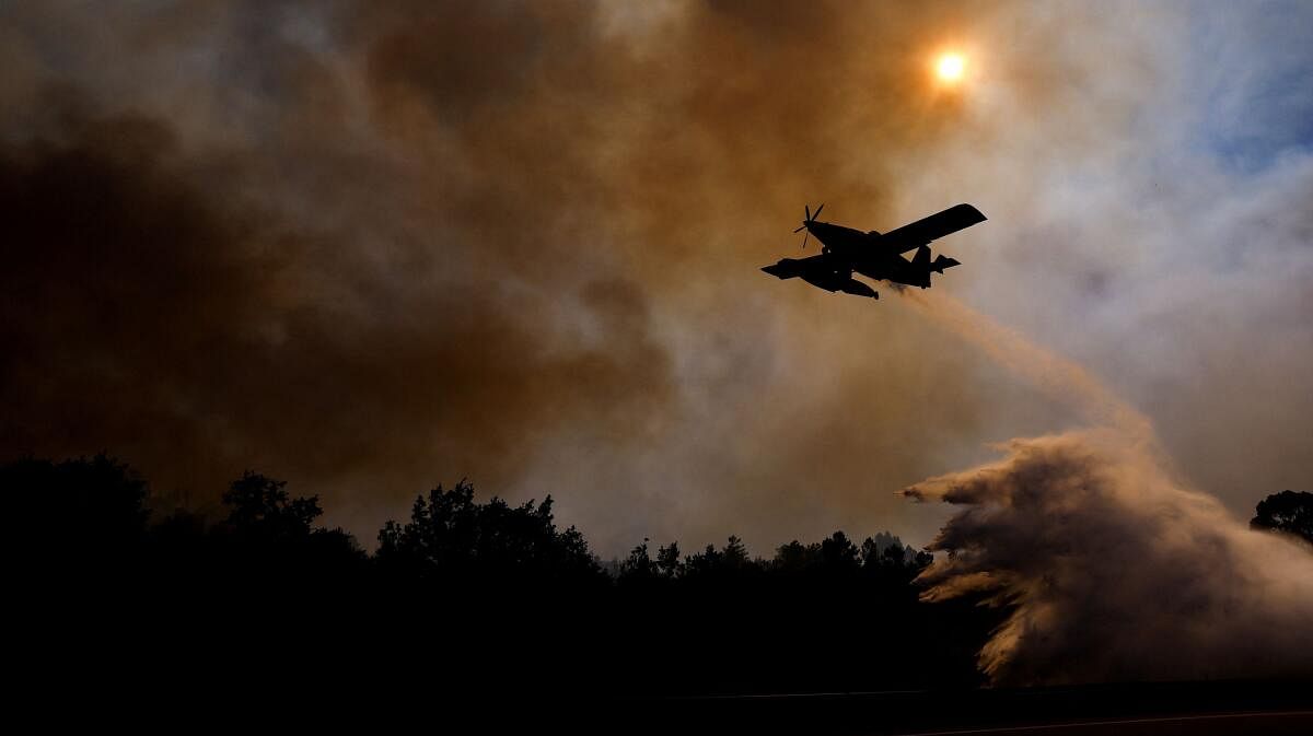 An airplane drops water on a wildfire along A25 Highway, near Freixiosa, Portugal, September 17, 2024.