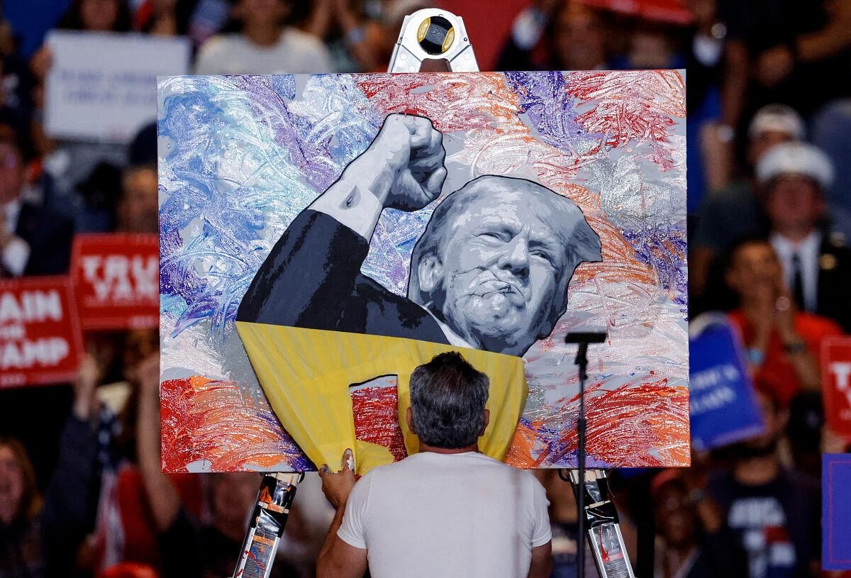 Artist Scott LoBaido paints a portrait of Republican presidential nominee and former U.S. President Donald Trump during a rally at Nassau Veterans Memorial Coliseum, in Uniondale, New York, U.S., September 18, 2024.