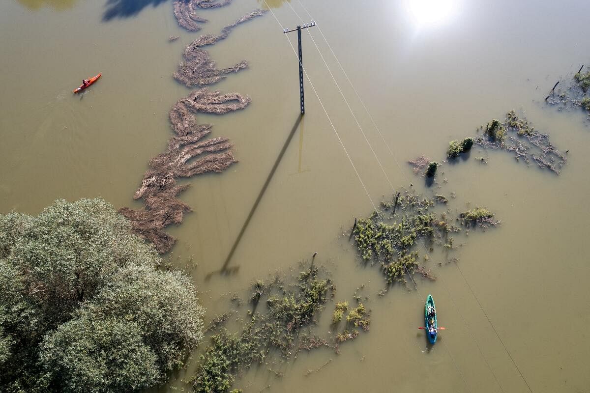 People row kayaks on flooded fields near Szodliget, Hungary, September 21, 2024.