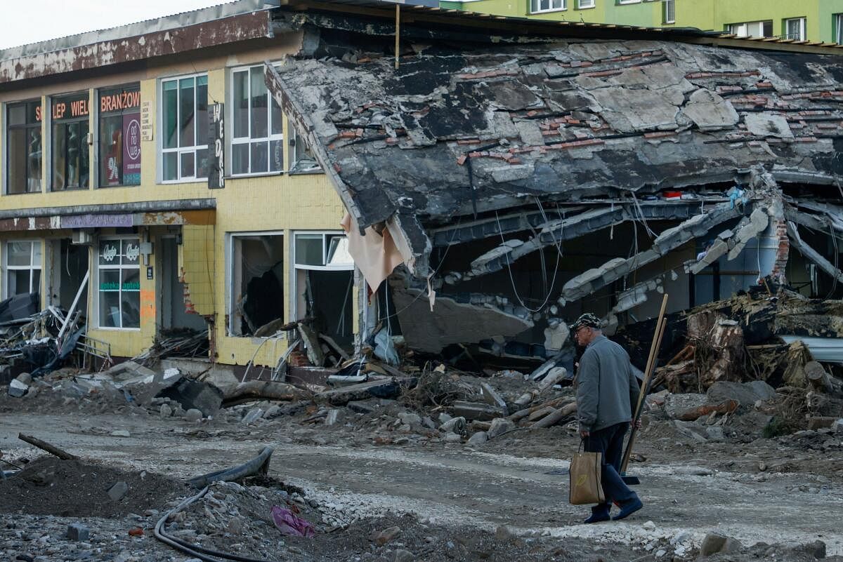 A man with a broom walks by a destroyed building days after intensive flooding in Stronie Slaskie, Poland, September 20, 2024.