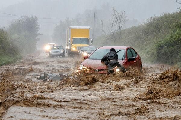 A local resident helps free a car that became stranded in a stretch of flooding road as Tropical Storm Helene strikes, on the outskirts of Boone, North Carolina, US September 27, 2024.