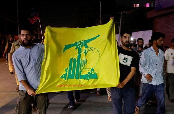 Kashmiri Shia Muslims hold a flag of Hezbollah during a protest against Israel following the killing of Hezbollah leader Sayyed Hassan Nasrallah in an Israeli airstrike in Beirut, in Srinagar September 28, 2024