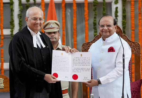 Delhi Lieutenant Governor Vinai Kumar Saxena with Justice Manmohan after administering him an oath as the Chief Justice of the Delhi High Court during a ceremony at the Raj Niwas, in New Delhi, Sunday, Sept. 29