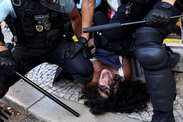 A counter-protester is being held on the ground by police officers, as supporters of the Chega party take part in a demonstration against what they say is "uncontrolled migration and insecurity on the streets," in Lisbon, Portugal.