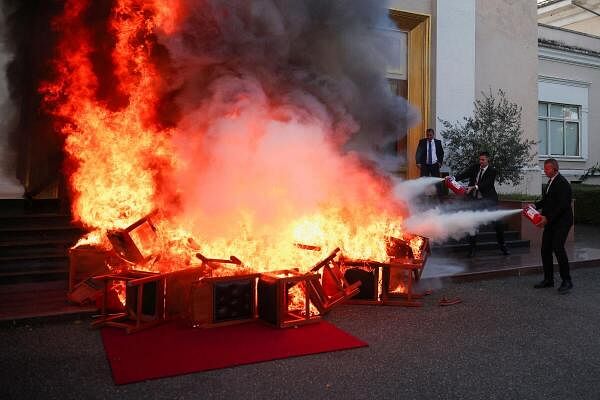 Members of National Guard use extinguishers as members of the opposition burn their chairs outside the parliament building, to protest against the government and the imprisonment of their colleague Ervin Salianji, in Tirana, Albania.