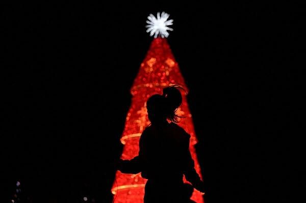 A woman jumps ropes in front of a Christmas tree, as the Christmas season kicks off as per a decree of Venezuela's President Nicolas Maduro, in Caracas, Venezuela.