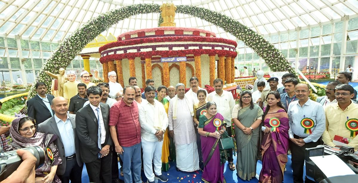 Chief Minister Siddaramaiah in front of a floral replica of the old Parliament house, at the Horticultural flower show, in Mysuru, on Thursday.