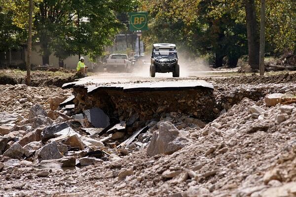 An all-terrain vehicle approaches a section of destroyed road in the aftermath of Hurricane Helene, in Barnardsville, North Carolina, US.