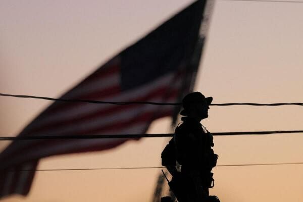 A member of the counter-sniper team is silhouetted during a rally of Republican presidential nominee former US president Donald Trump, on the day Trump returns to the site of the July assassination attempt against him, in Butler, Pennsylvania, US.