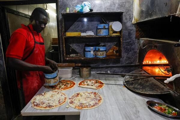 An employee prepares orders at Chez Aalat fast food restaurant in Abidjan, Ivory Coast.