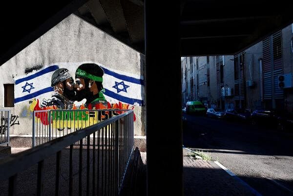 Graffiti depicting members of Hamas and ISIS kissing, by Grafitiyul, in Tel Aviv