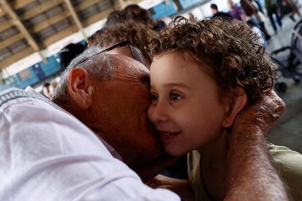 Brazilian citizens hug as they arrive from Lebanon in Brazil's Air Force aircraft, during an evacuation plan amid the ongoing hostilities between Hezbollah and Israeli forces in Lebanon, in Guarulhos, Brazil