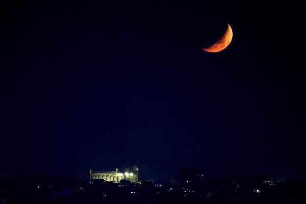 The moon is seen over a building in Beirut southern suburbs, amid the ongoing hostilities between Hezbollah and Israeli forces, as seen from Sin El Fil, Lebanon 