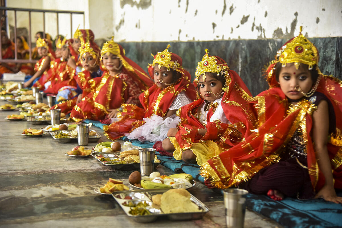 Girls eat 'prasadam' during 'Kumari Puja' as part of Navaratri festival, in Varanasi.