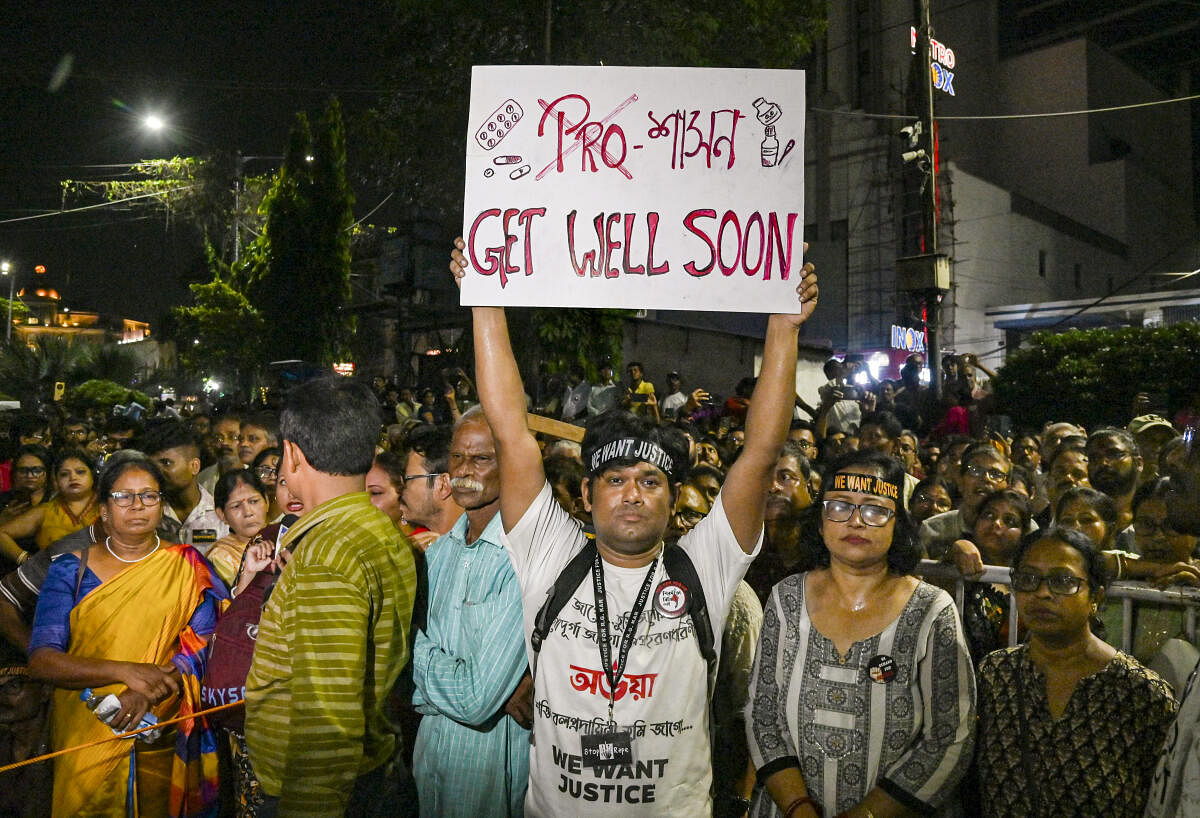 A man holds a placard during a 'mass convention' called by junior doctors near the hunger strike site, protesting against the alleged rape and murder of a trainee doctor, in Kolkata.