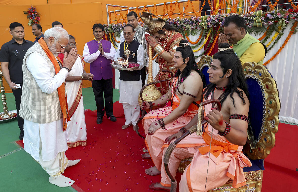 Prime Minister Narendra Modi offers prayers before artists dressed as Lord Rama, Lakshmana and Hanumana during Dussehra celebration, at Red Fort in New Delhi.