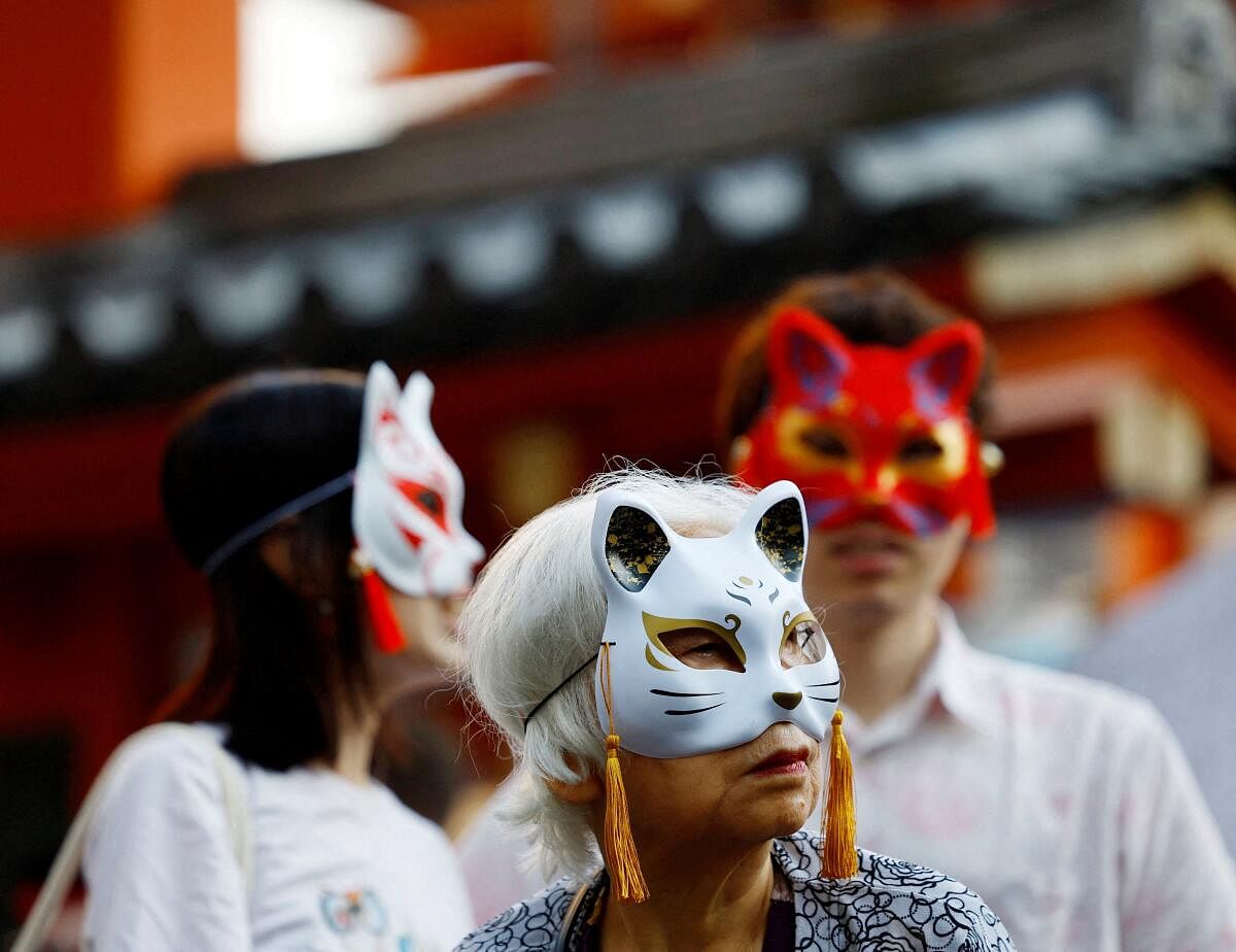 People wait for a parade at the Kagurazaka Bakeneko Festival, attended by participants dressed as cats and supernatural cats, known as 