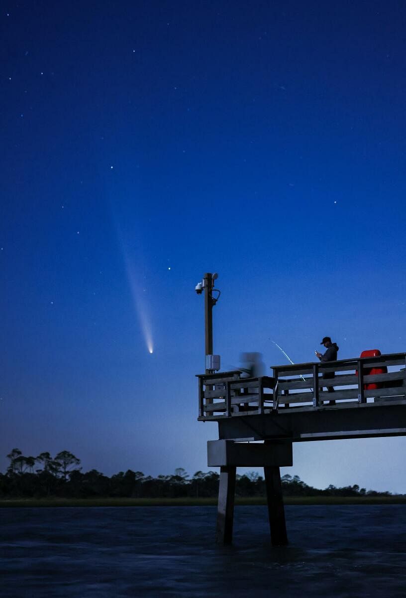 Comet C/2023 A3 (Tsuchinshan-ATLAS) is visible shortly after sunset in the western sky over the Fisherman’s Walk Pier as two men fish, in Tybee Island, Georgia, US.