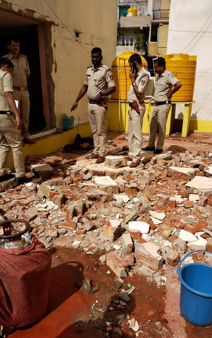 Police and fire department personnel inspect the explosion site in BTM Layout. SPECIAL ARRANGEMENT 