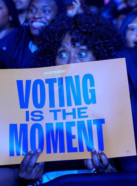 A supporter holds a poster as Former U.S. first lady Michelle Obama hosts a rally for Democratic presidential nominee U.S. Vice President Kamala Harris at Gateway Center Arena in College Park.