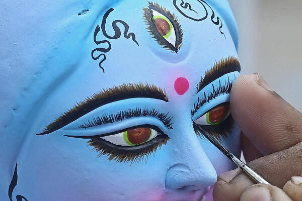 An artist gives final touches to an idol of the Goddess Kali ahead of the ‘Kali Puja’, in Agartala.