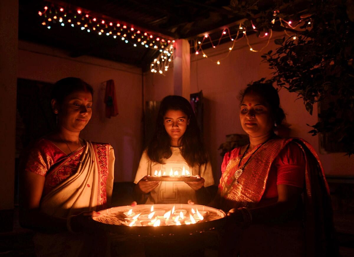 Women light 'diyas' during the Diwali festival celebration, at Tezpur in Sonitpur district, Assam, Thursday, Oct 31, 2024.