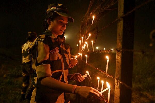 Border Security Force (BSF) personnel light candles to celebrate the Diwali festival near the Indo-Bangladesh Border, at Atila, Tapan, in Dakshin Dinajpur district of West Bengal.