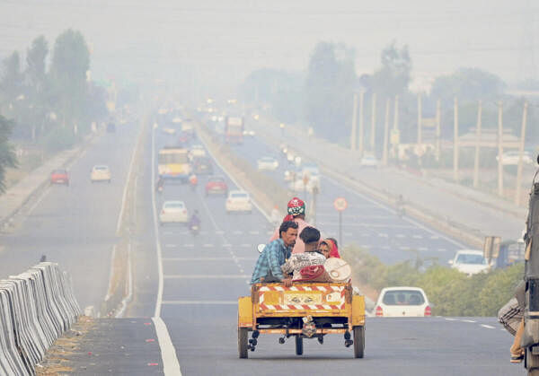 Vehicles move amid smog after the Diwali festival, at Chandigarh highway in Patiala, Punjab.