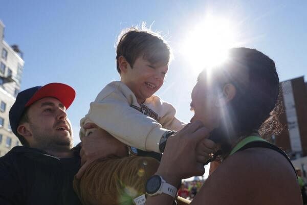 A competitor embraces a child on the Pulaski Bridge in the Queens borough of New York City, New York US.