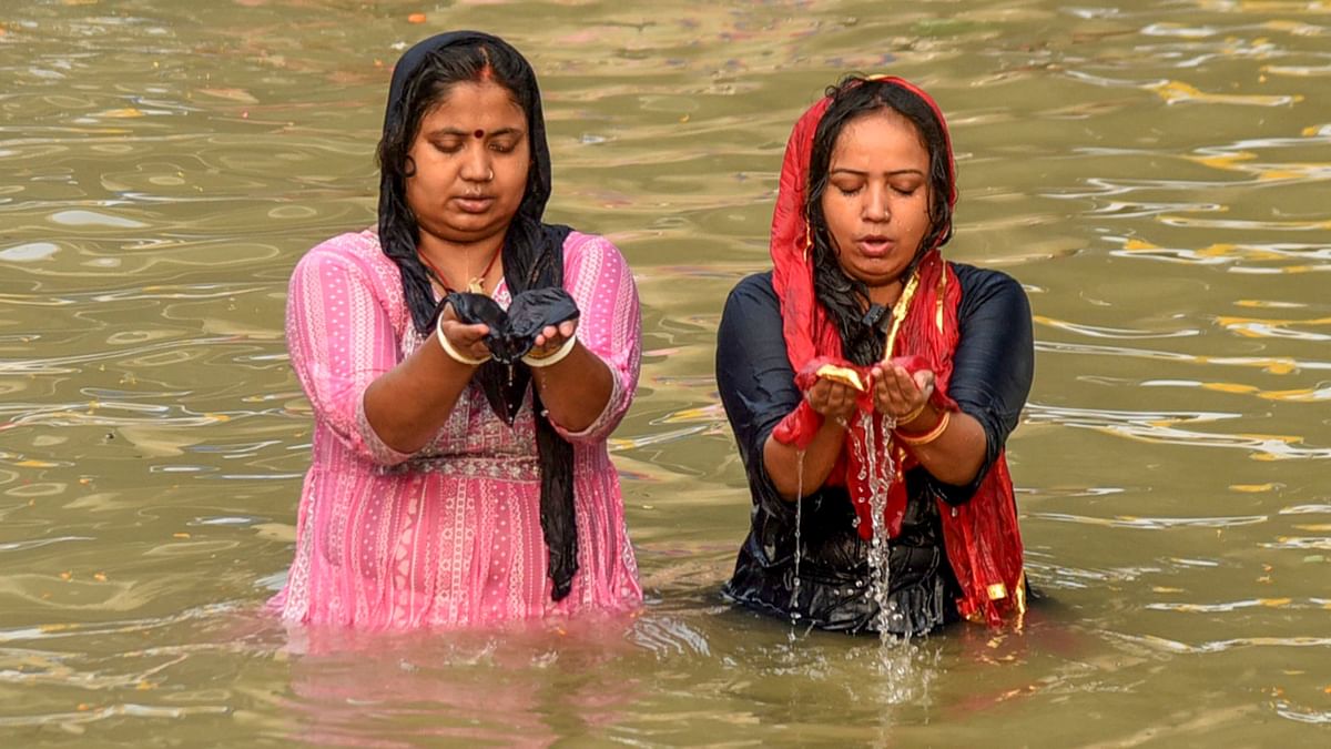 Devotees offer prayers while taking a holy dip in the Ganga river during the 'Nahay Khay' ritual of the Chhath Puja festival, in Patna.