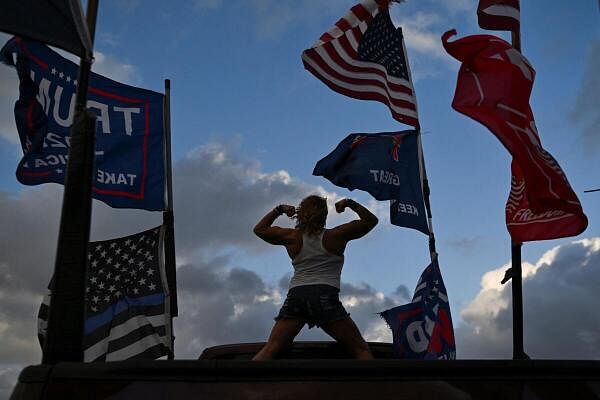 Nikki Fuller, 56, flexes her muscles while standing on a truck bed, as supporters of Republican presidential nominee and former US President Donald Trump gather ahead of the US presidential election in West Palm Beach, Florida, US November 4, 2024.