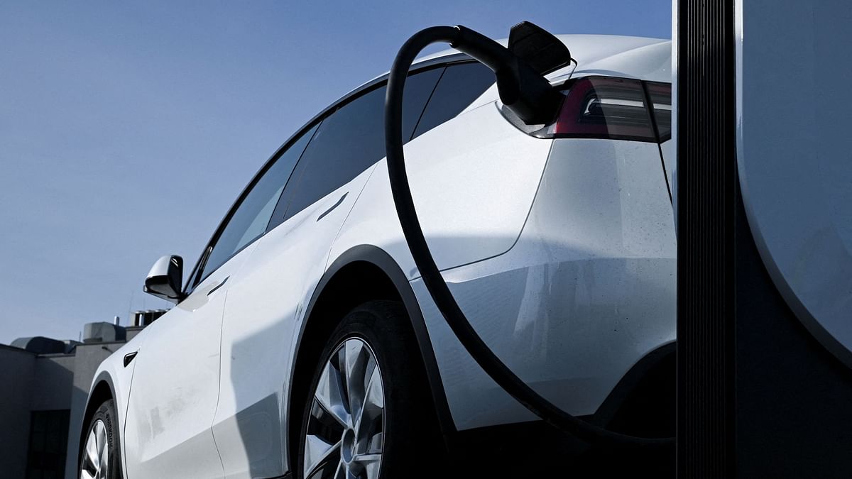 FILE PHOTO: A Tesla car being charged at a Tesla electric vehicle charging station in a car park of the A10 shopping center in Wildau near Berlin, Germany, March 20, 2024. 