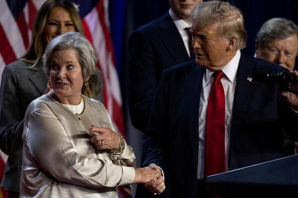 Republican presidential nominee and former US President Donald Trump shakes hands with his senior advisor Susie Wiles as he speaks, following early results from the 2024 U.S. presidential election in Palm Beach County Convention Center, in West Palm Beach, Florida