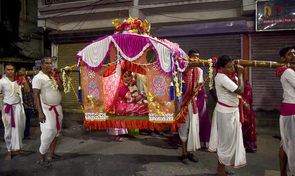 Devotees carry a child on a ‘palki’ during ‘Kumari Puja’, in Kolkata.